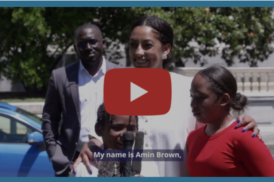 A still from the new "Broken Hope" video shows a man in the background and a woman in the foreground, flanked by two children